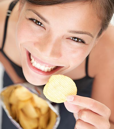 Happy woman eating healthy chips